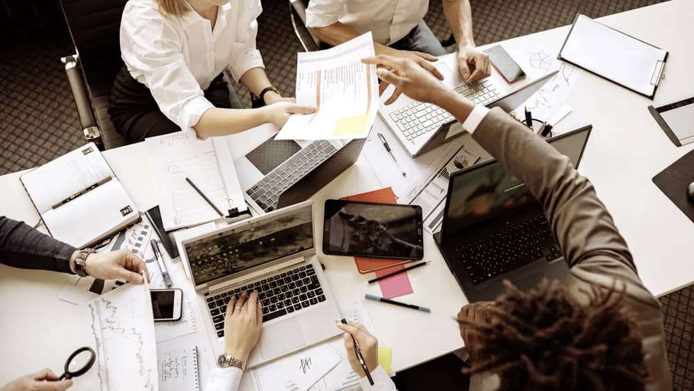 Diverse team collaborating in a modern office with laptops