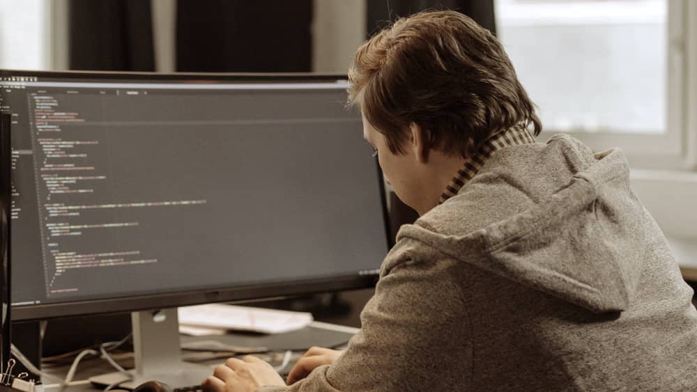 Developer working at a desk with large monitors
