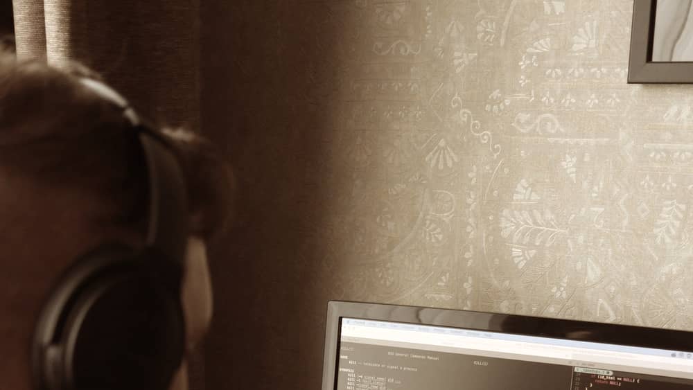Focused programmer working at a dual monitor setup