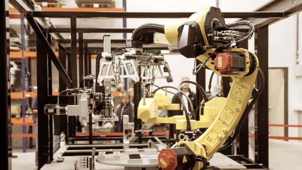 Yellow industrial robotic arm operating in a manufacturing facility