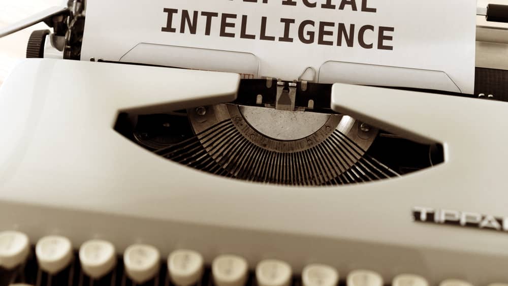 Typewriter with a page reading ARTIFICIAL INTELLIGENCE