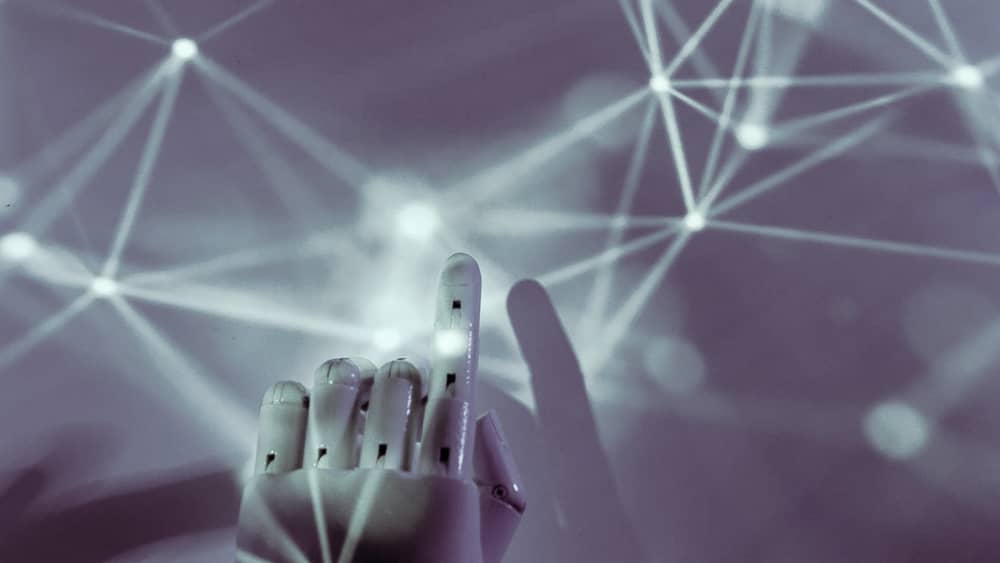 Robotic hand reaching toward a network of connected nodes