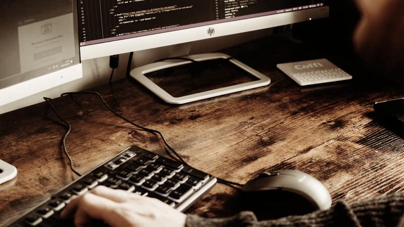 Developer writing code at a desktop monitor